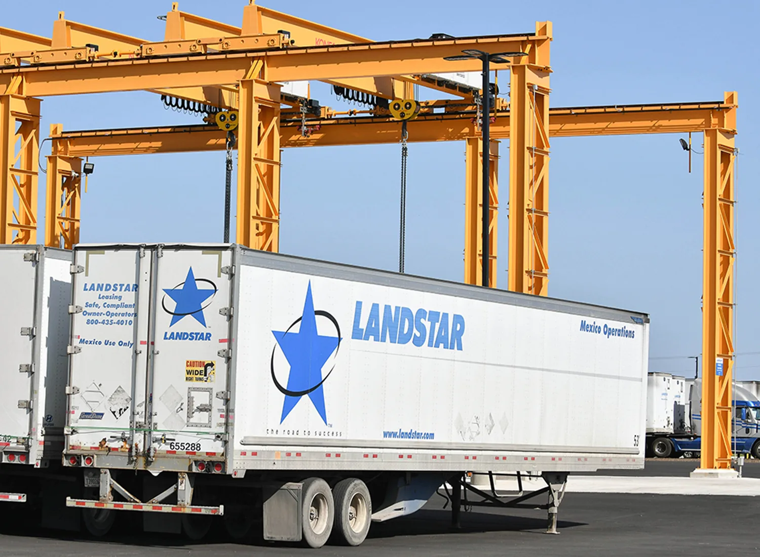 Grúa puente maniobrando remolques en las instalaciones cross-dock de Laredo, Texas.